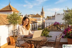 Spain digital nomad visa - laptop on a terrace table overlooking a Spanish plaza