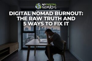 Digital nomad burnout - exhausted remote worker with head in hands at laptop in empty apartment